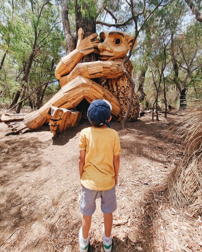Young boy staring at the Giants of Mandurah statue